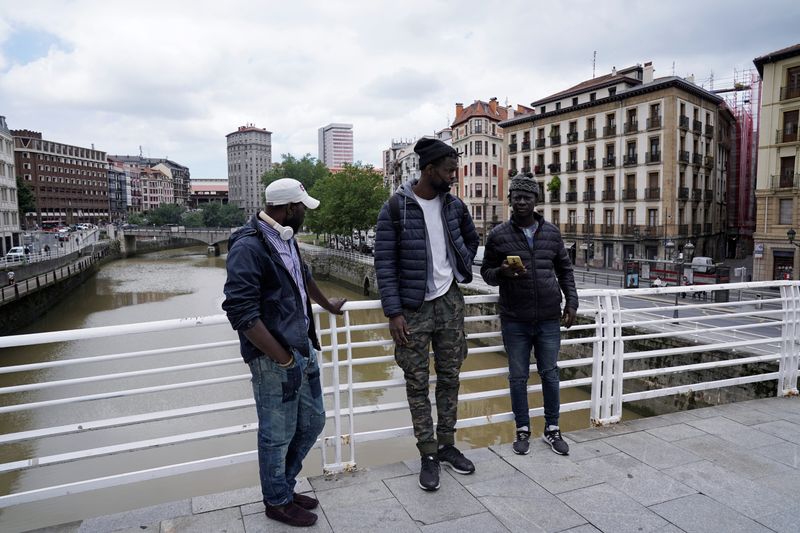 Mohamed Fadal Diouf, 26, from Senegal, stands with friends Matar