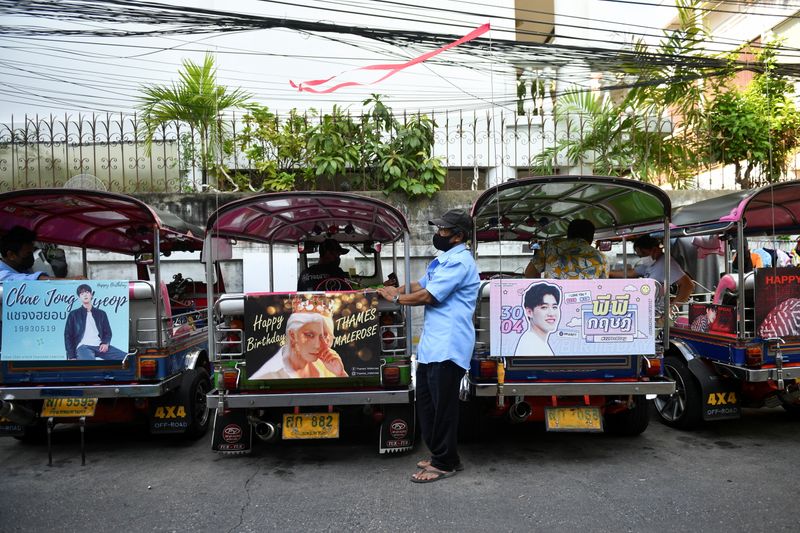 Tuk-tuk drivers, with their vehicles decorated with banners of Thai