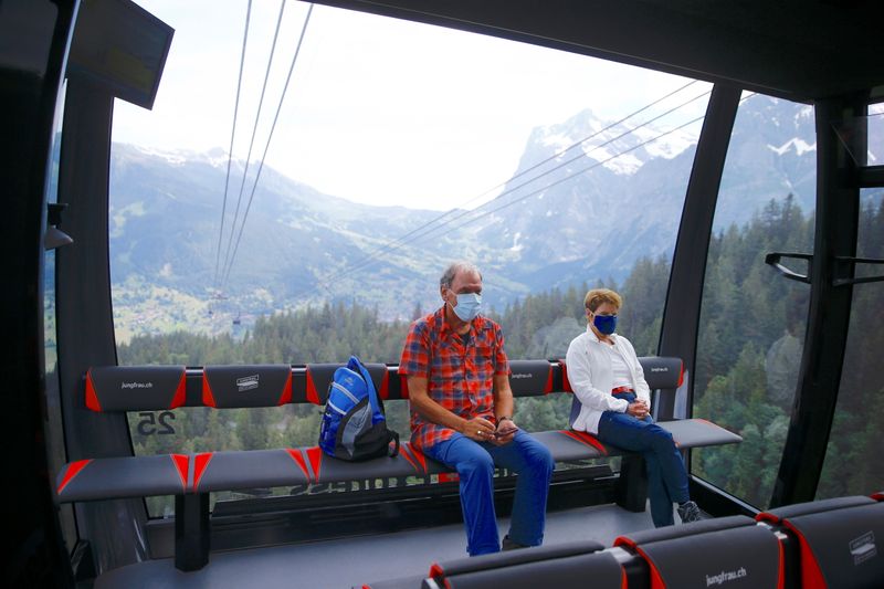 Tourists sit in a cabin of the Eiger Express cable