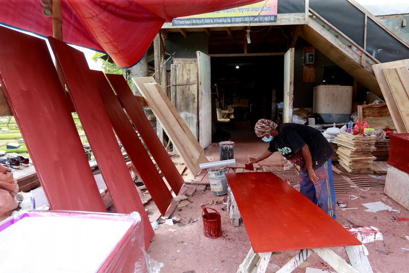 FILE PHOTO: A coffin maker prepares planks for coffins ordered