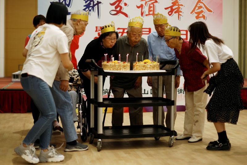 Ding and other celebrants blow candles at a care home