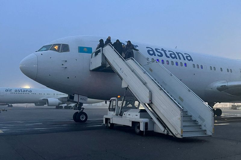 Passengers are seen on the ramp of an Air Astana