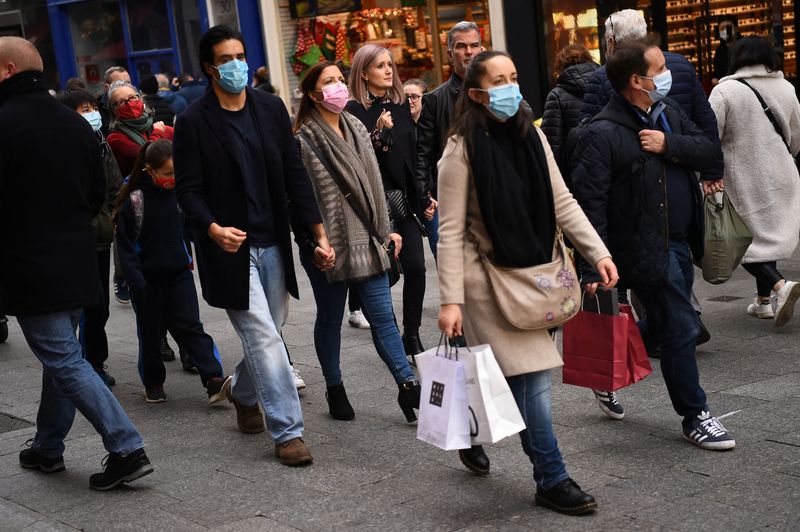 People wear protective face masks while out for Christmas shopping
