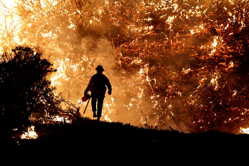 FILE PHOTO: A firefighter works as the Caldor Fire burns