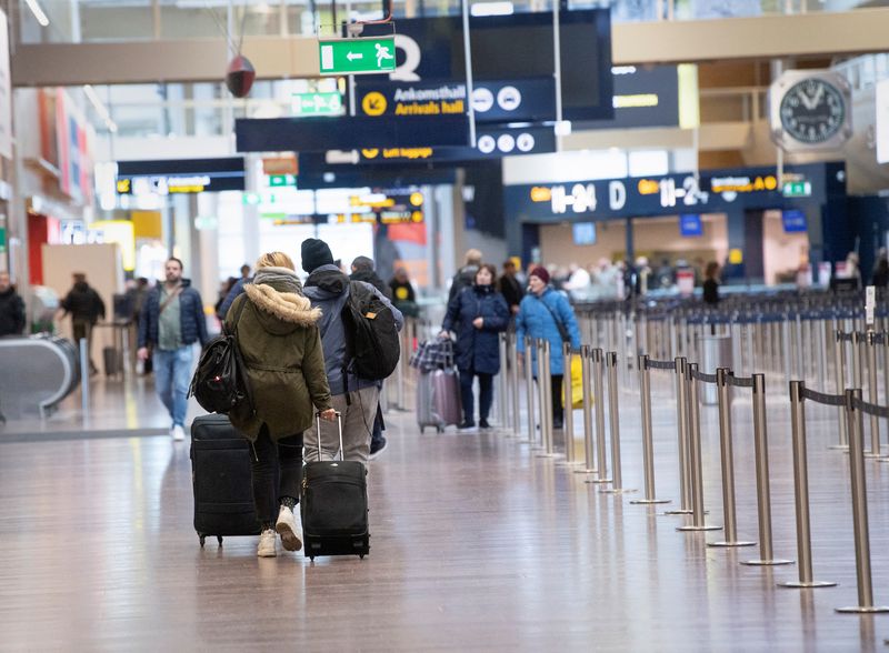 FILE PHOTO: Travelers walk at Arlanda International Airport following the