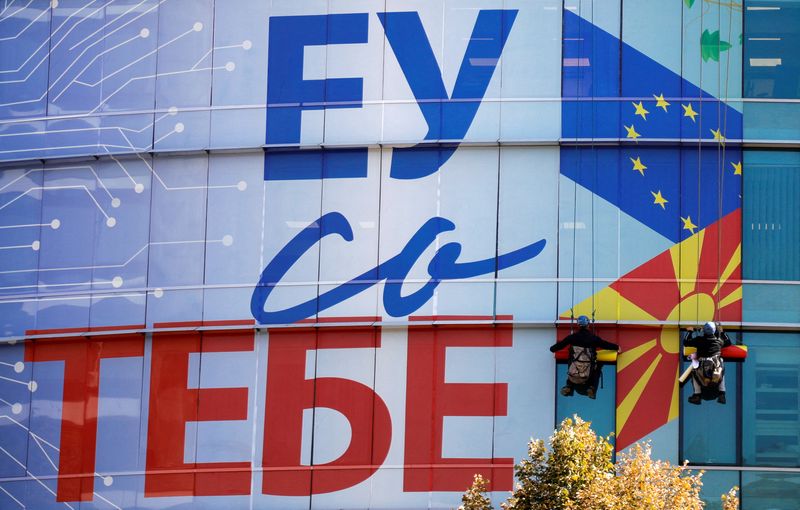 FILE PHOTO: Workers add a new decorative poster saying ‘EU