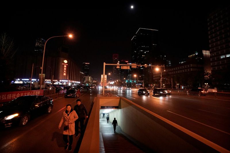 People walk through an underpass at night in downtown Beijing