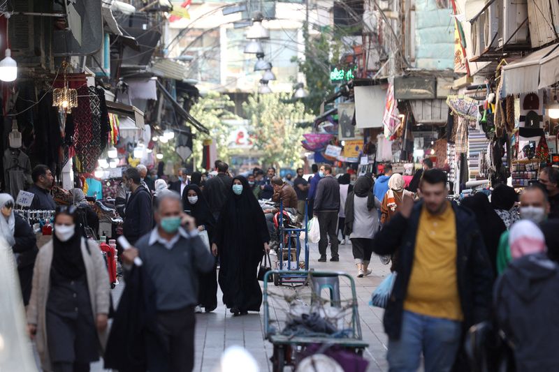 FILE PHOTO: Iranians walk down a market street in Tehran
