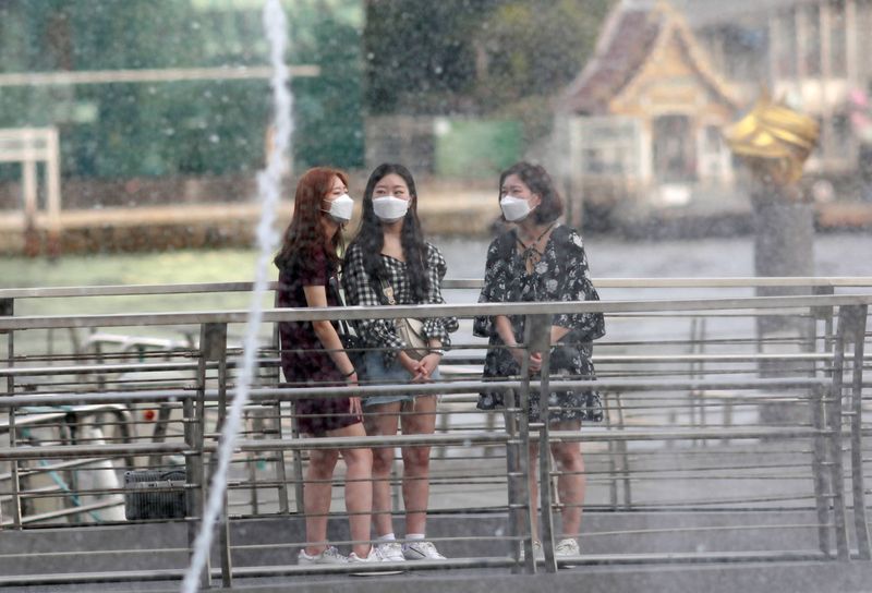 FILE PHOTO: Tourists wear masks as they visit a shopping