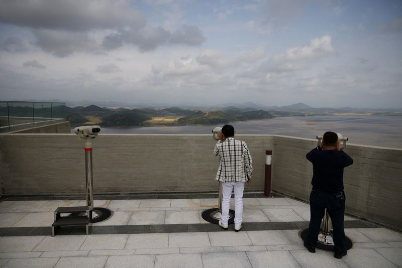 FILE PHOTO: People look at North Korea’s propaganda village Kaepoong