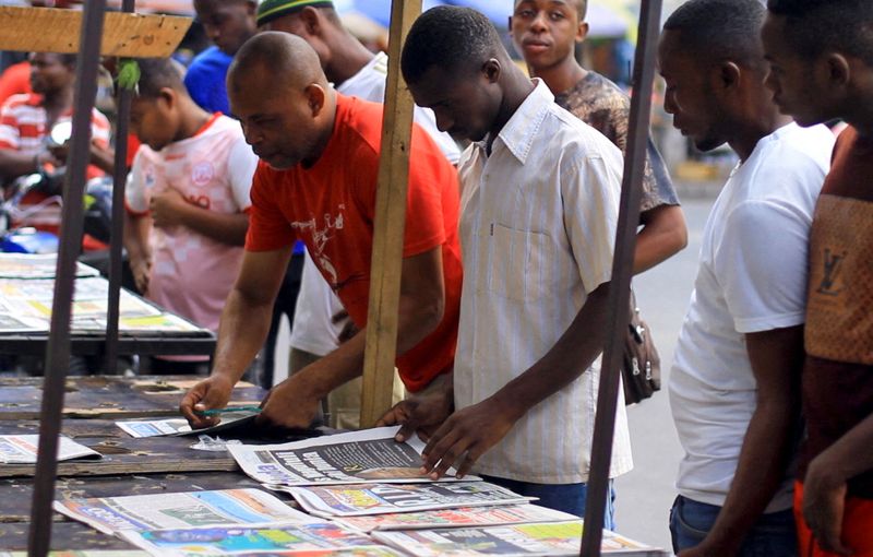 FILE PHOTO: Civilians read newspapers on display following the death