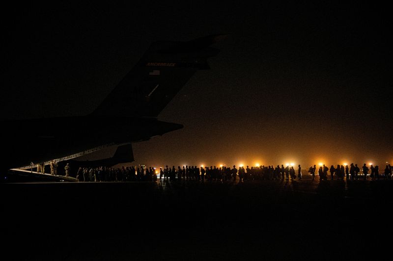 FILE PHOTO: Evacuees from Afghanistan board a military aircraft during