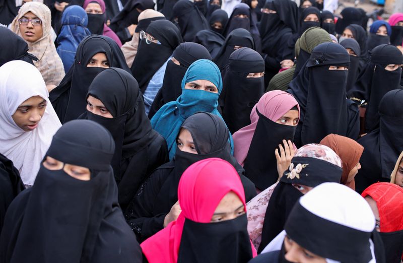 Women wearing hijabs attend a protest against the recent hijab