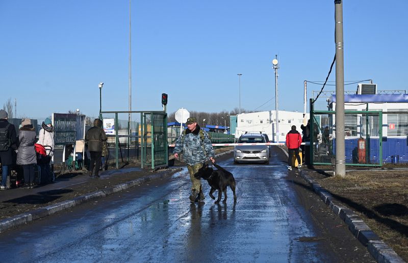 A border guard walks with a dog at the Matveyev
