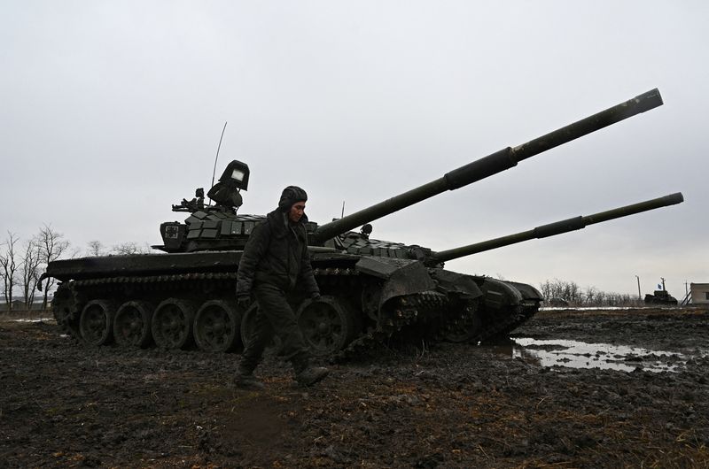 FILE PHOTO: A Russian service member walks past T-72B3 main