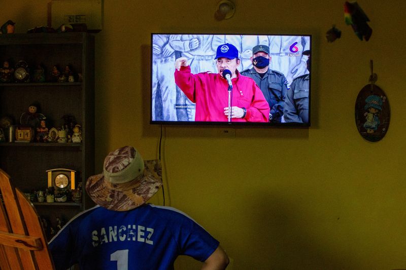 A man watches a televised speech of Nicaraguan President Daniel