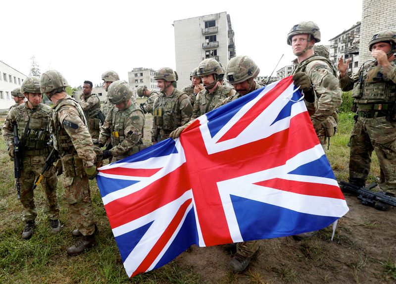 FILE PHOTO: British Royal Marines servicemen hold Union Jack after