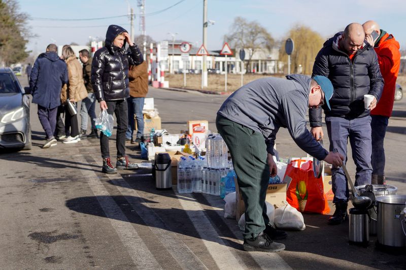 Romanians serve tea, water and food to people crossing the