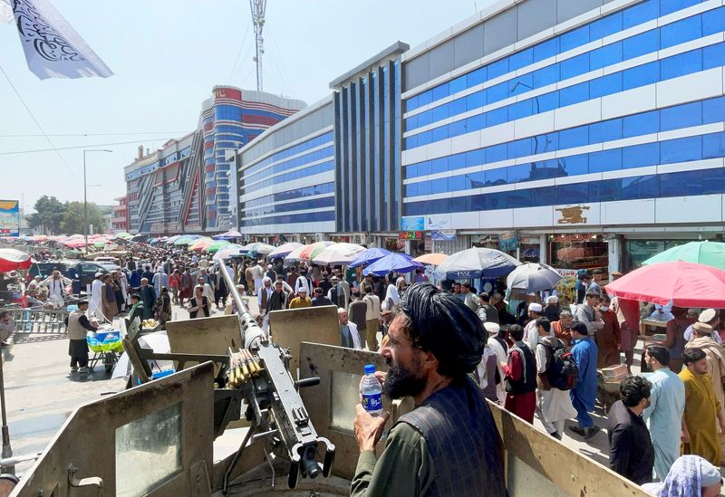 FILE PHOTO: Taliban security forces stand guard among crowds of