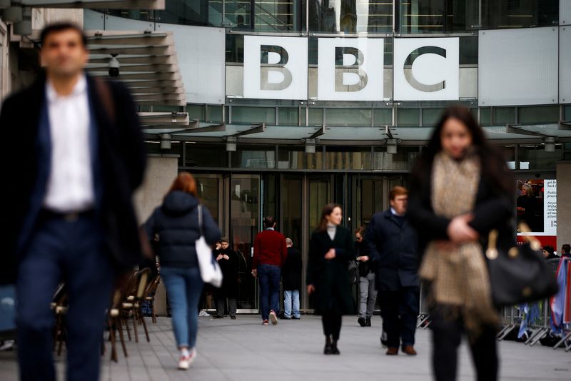 FILE PHOTO: Pedestrians walk past a BBC logo at Broadcasting