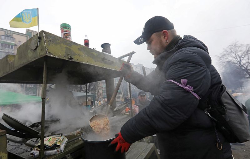 A man prepares food for local residents and members of