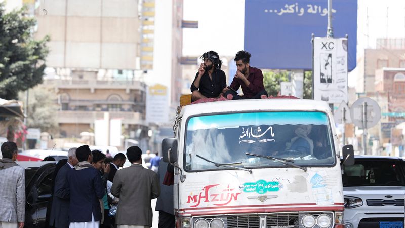 People ride atop a bus amid acute fuel shortages in