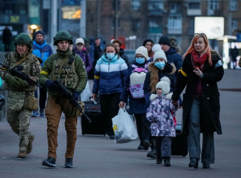 Servicemen escort people with children from Kyiv’s Central Children’s Hospital