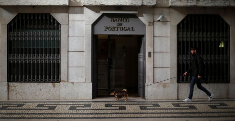 FILE PHOTO: A man walks with his dog outside Bank