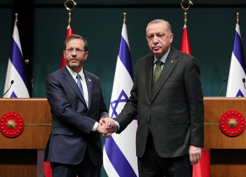 Turkish President Erdogan and his Israeli counterpart Herzog shake hands