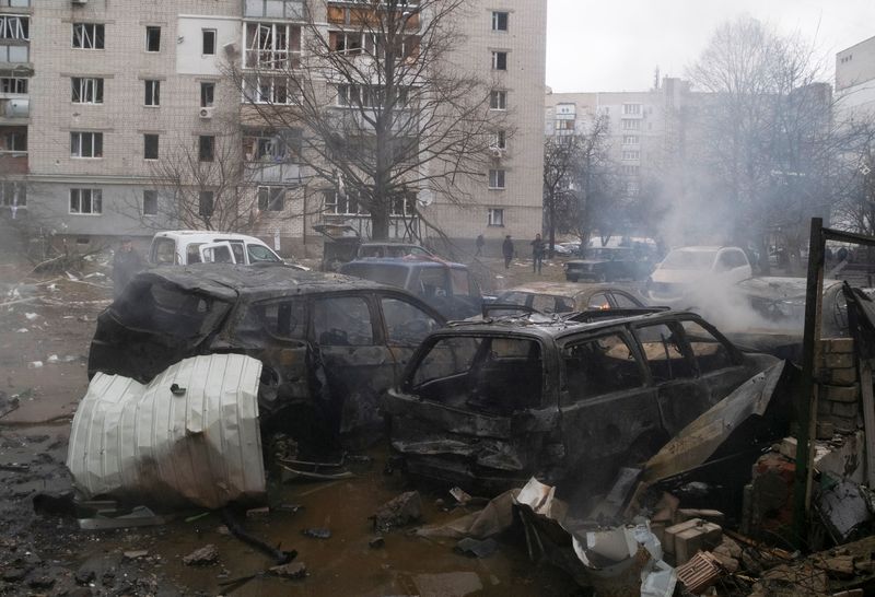 Charred cars are seen next to a residential building following