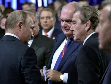 FILE PHOTO: Russian President Putin and former German Chancellor Schroeder,