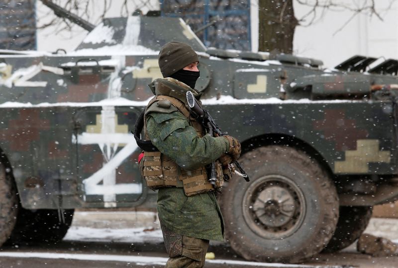 A service member of pro-Russian troops stands on a street