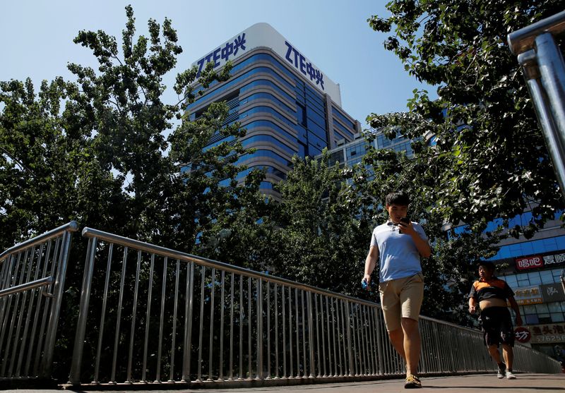 FILE PHOTO: People walk past a building of China’s ZTE