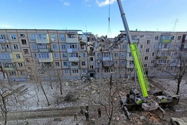Rescuers remove debris from a residential building damaged by an