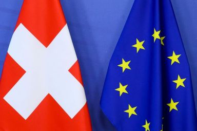 FILE PHOTO: Switzerland’s national flag and the European Union flag