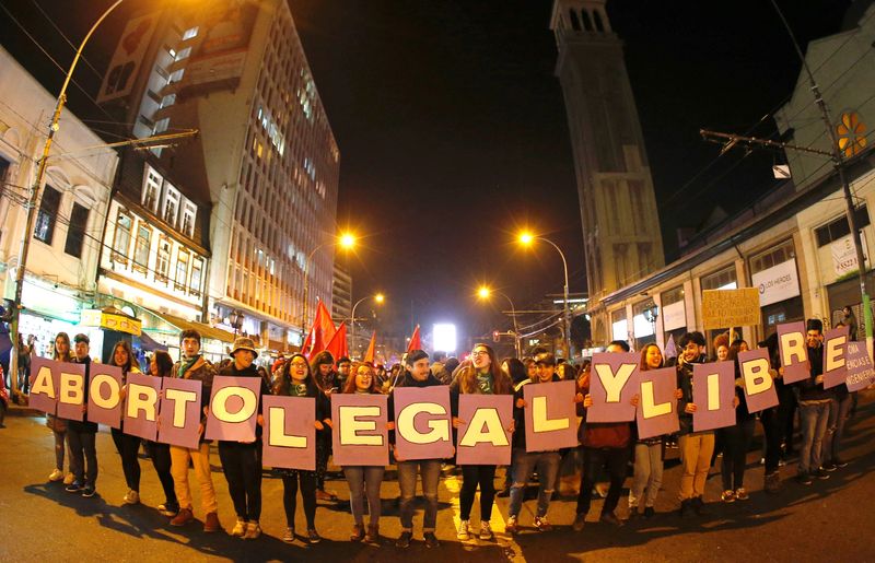 FILE PHOTO: Demonstrators hold placards reading “abortion legal and free”