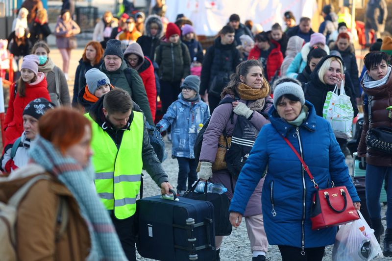 People fleeing Russia’s invasion of Ukraine arrive at a border