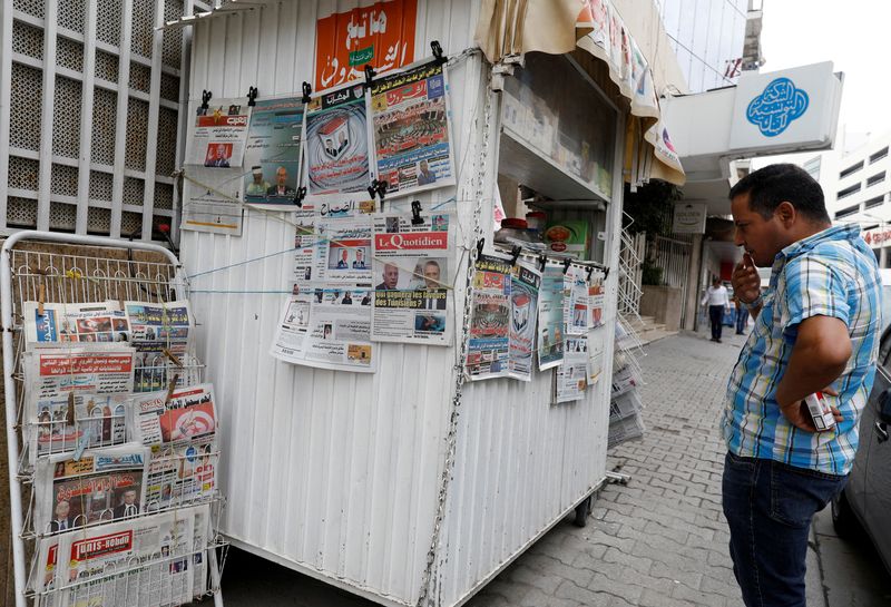 FILE PHOTO: A man looks at local newspapers displaying pictures