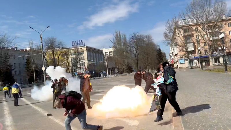 Demonstrators react to stun grenades thrown by Russian troops in