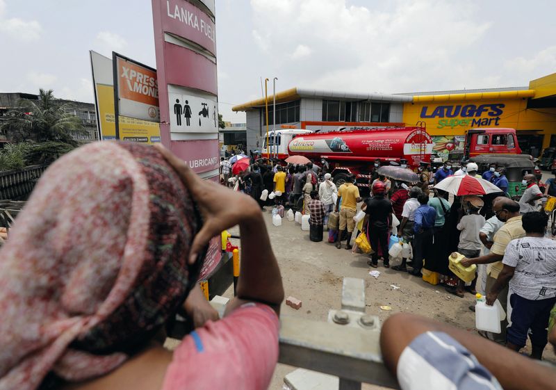 People queue to buy kerosene at a fuel station in