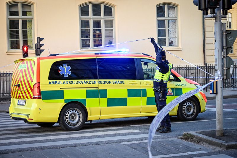 A police officer gives access to an ambulance to the