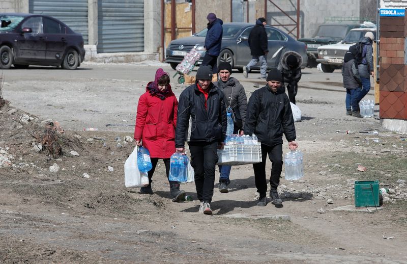 FILE PHOTO: Local residents carry bottles with water in the