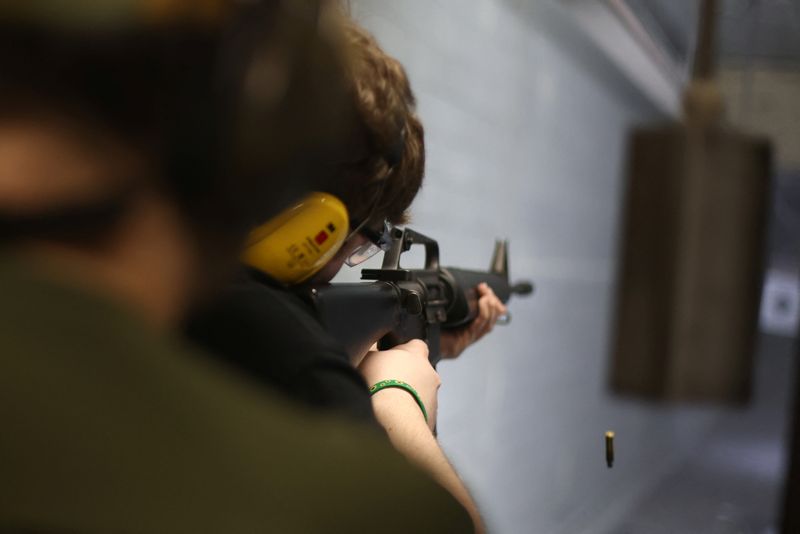 People attend a practice session at a shooting range in