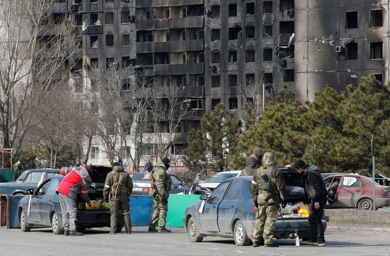 FILE PHOTO: Service members of pro-Russian troops check cars in