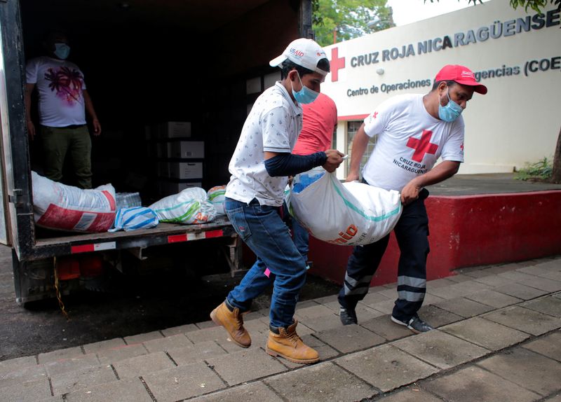 Members of the Nicaraguan Red Cross carry packed food to