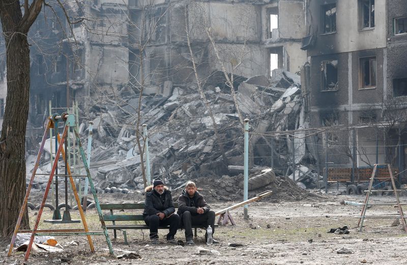 Local residents sit on a bench in the besieged city