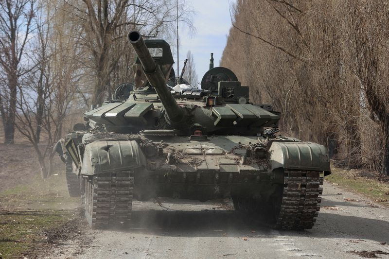 Ukrainian service member drives a captured Russian T-72 tank in