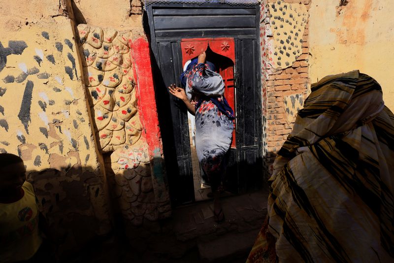 A woman enters her house in Khartoum