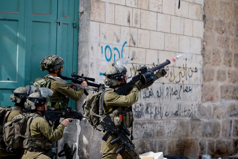 Israeli soldier uses a weapon amid clashes with Palestinian protesters,