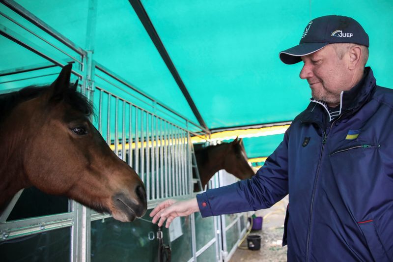 Parkhomchuk, founder of Ukrainian Equestrian Federation Charity Foundation pets a